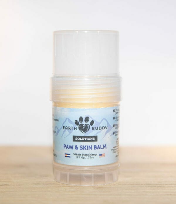 A tube of Earth Buddy hemp 125 mg Paw & Skin Balm for dogs on a wooden table. Perfect for dry skin & noses.