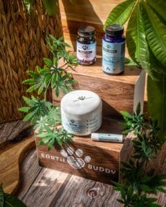earth buddy’s maxx life glutathione in black and purple bottle, mushrooms for dogs in a blue bottle, gut health colostrum for dogs in white jar, and skin and paw balm for dogs and cats on an earth buddy shelf.