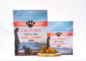 Earth Buddy Beef & Pumpkin CBD treats for dogs in blue and red packaging with some limited ingredient treats in front of the bags. 