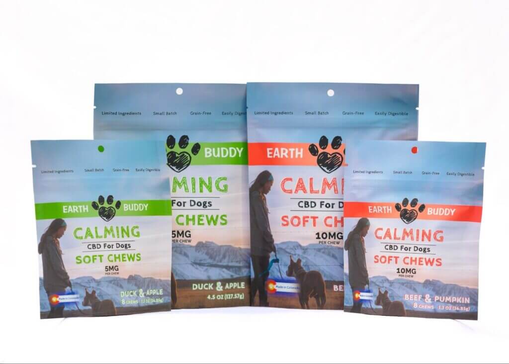 Earth Buddy’s new cbd calming treats for dogs come in blue packaging with colored stripes representing duck & apple flavor and beef & pumpkin flavor. 