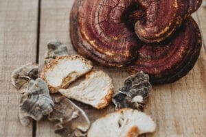 Functional mushrooms for dogs & cats used in Earth Buddy allergy supplements on a wood table with reishi & turkey tail.