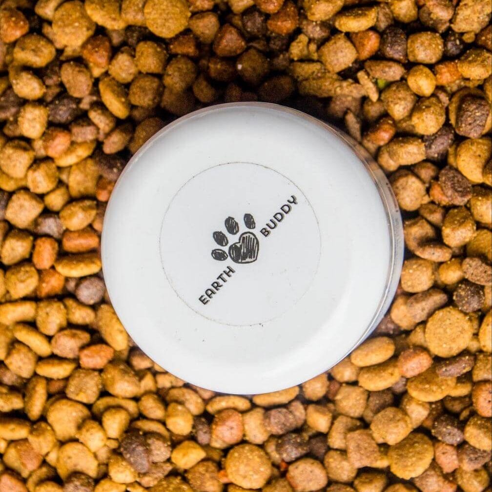 Earth Buddy Colostrum with CBD for pets in a pile of dog food. CBD can be added to food and actually increases absorption.