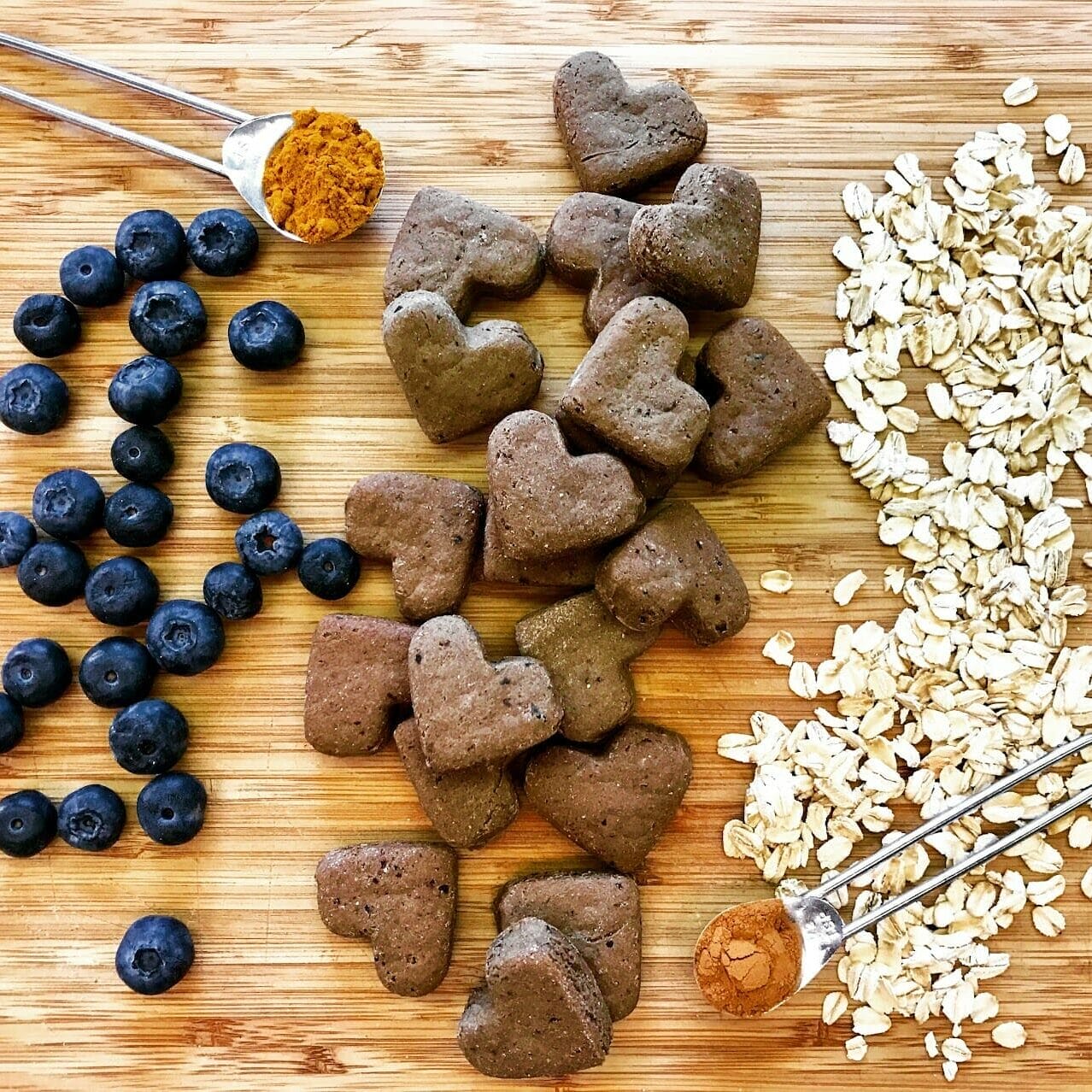 ingredients spread out on a cutting board. Blueberries, oats, turmeric, and cinnamon are healthy ingredients pet owners can look for in dog food.